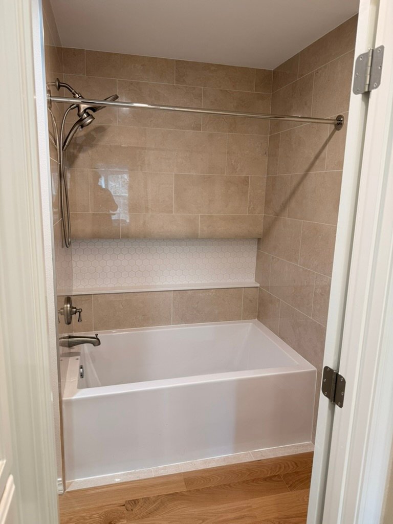 Finished tiled tub surround with full length niche after bathroom remodel